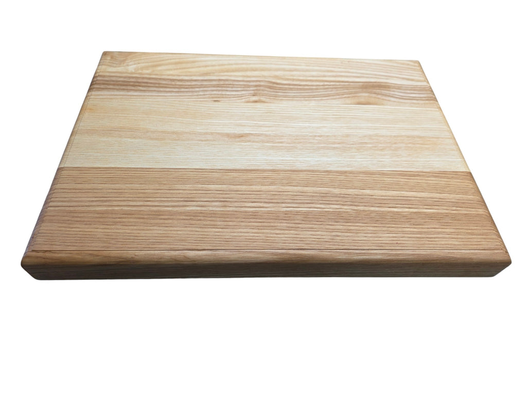 Ash chopping board with rounded edges in use preparing food in kitchen