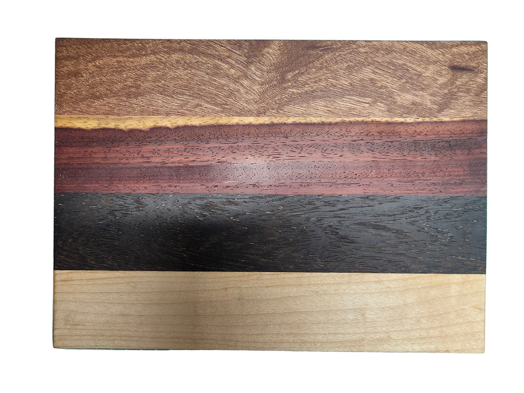 Close up of oak black palmwood pink ivory and kiaat wood grain on cheese board